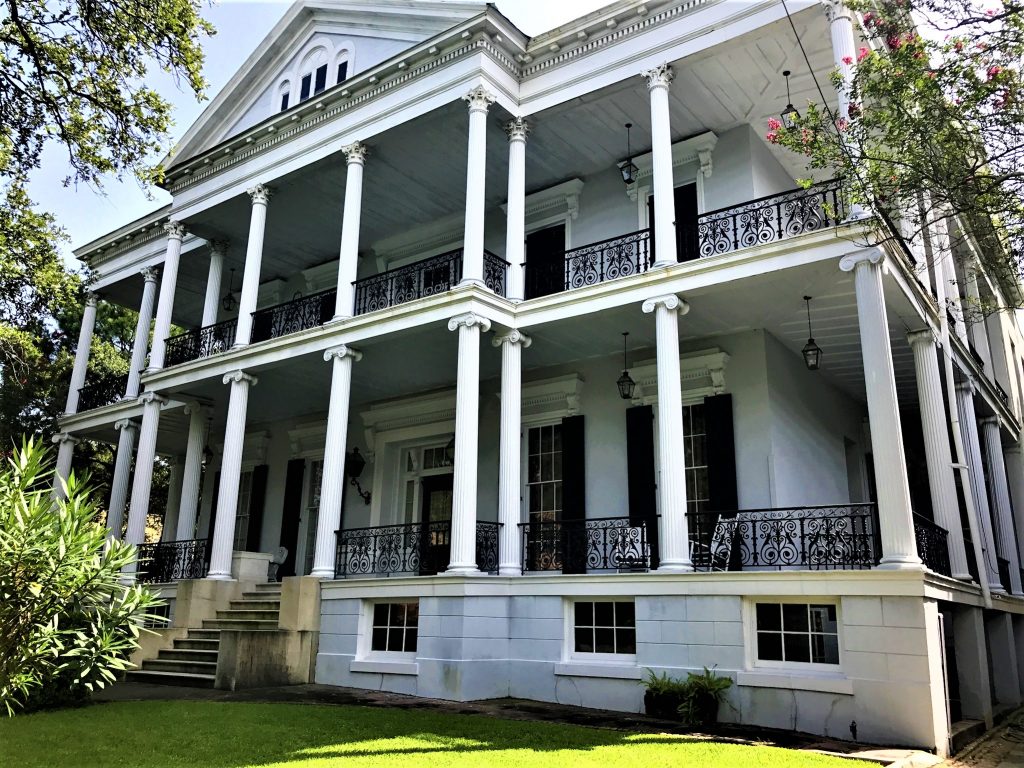 a large white house with columns and a lawn