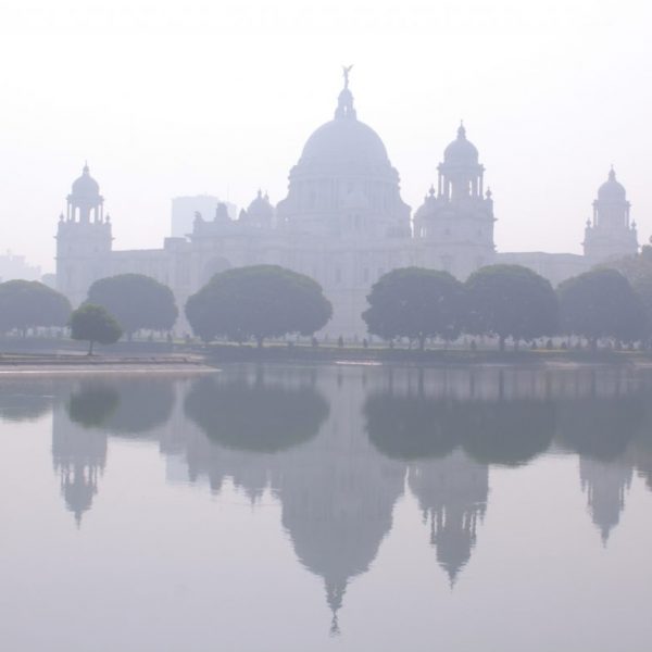 a building with domes and trees reflecting in water