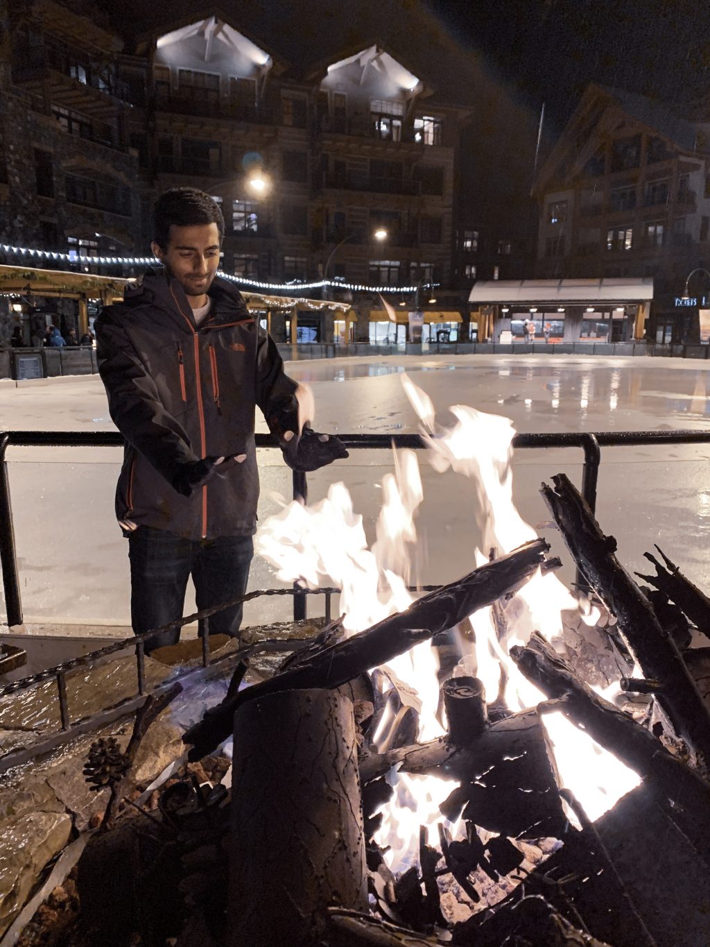 a man standing next to a fire