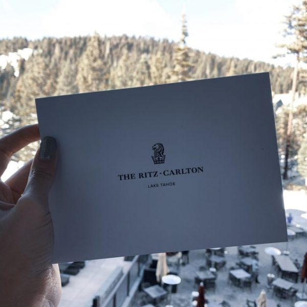 a hand holding a white card with a snowy landscape in the background