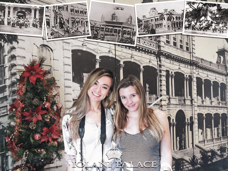 two women standing next to a christmas tree