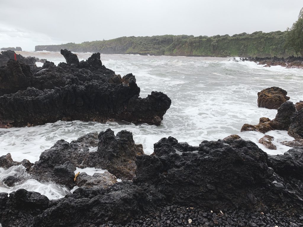 a rocky beach with waves crashing on rocks