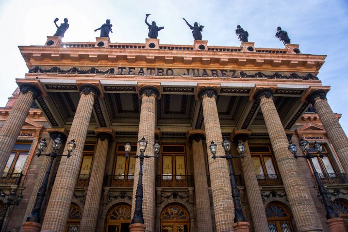 a building with pillars and statues on top