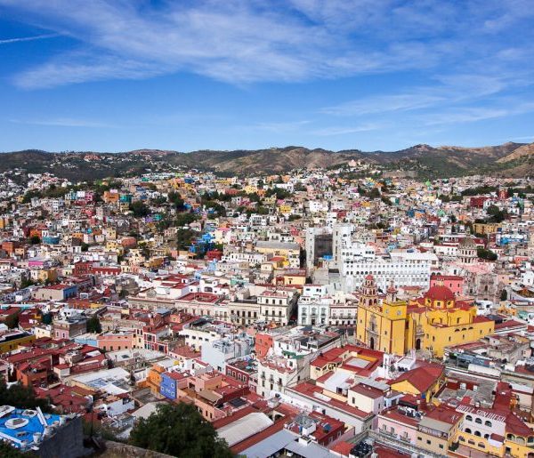 a city with many buildings and mountains in the background