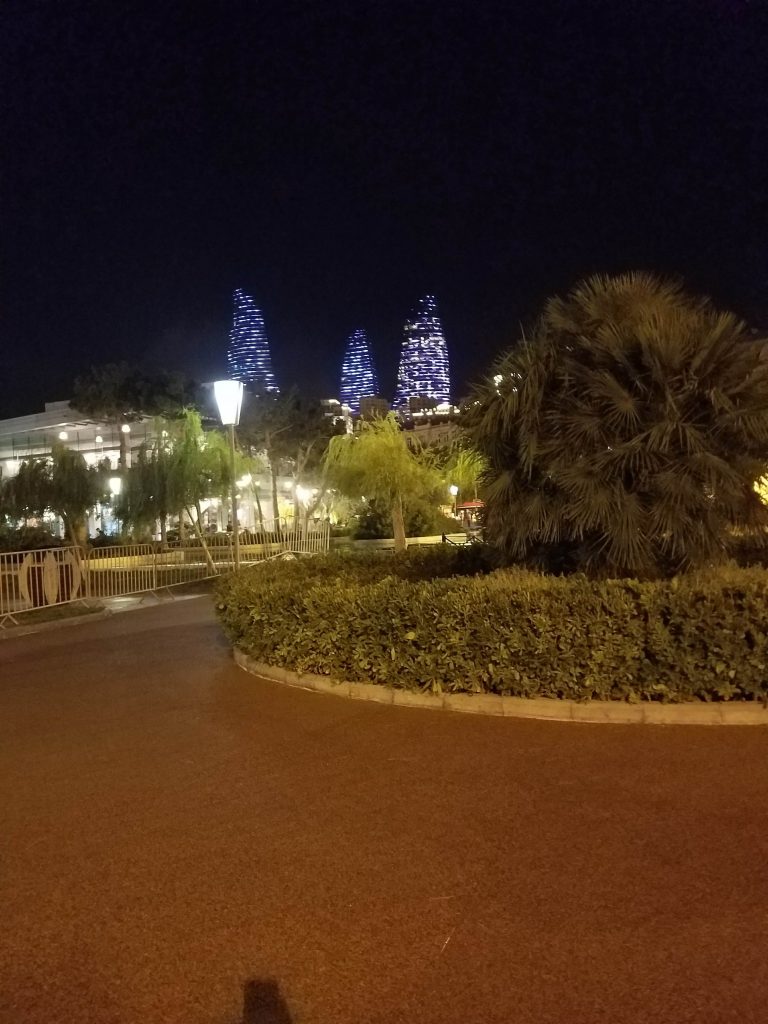 a road with a fence and a tree in front of a building