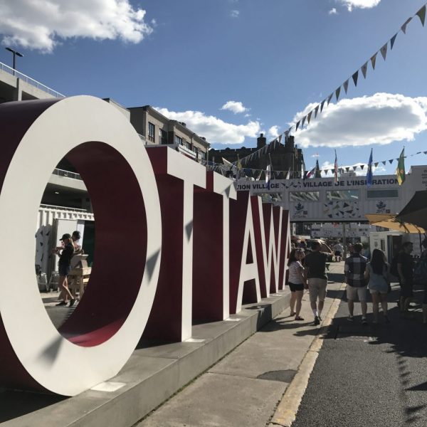 a large sign with people walking around