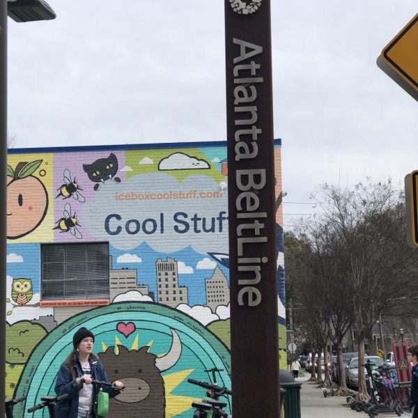 a woman on a bicycle next to a sign