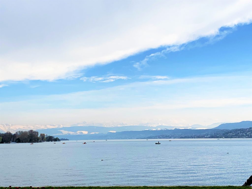 a body of water with boats and mountains in the background