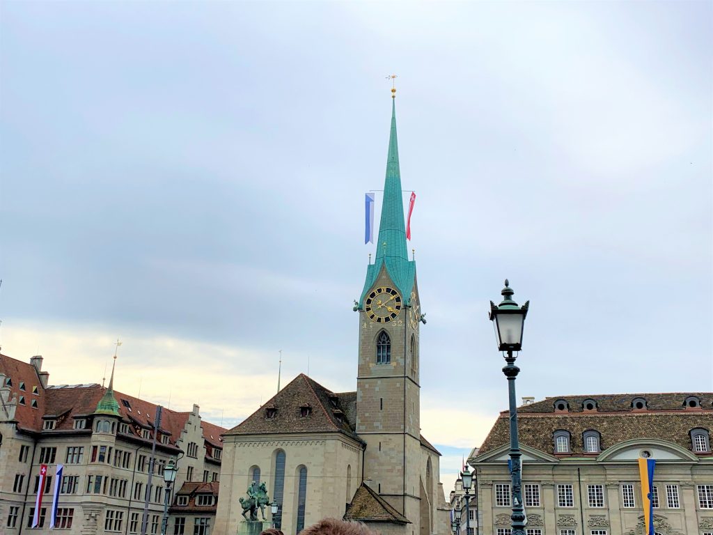 a building with a clock tower and a statue in front of it