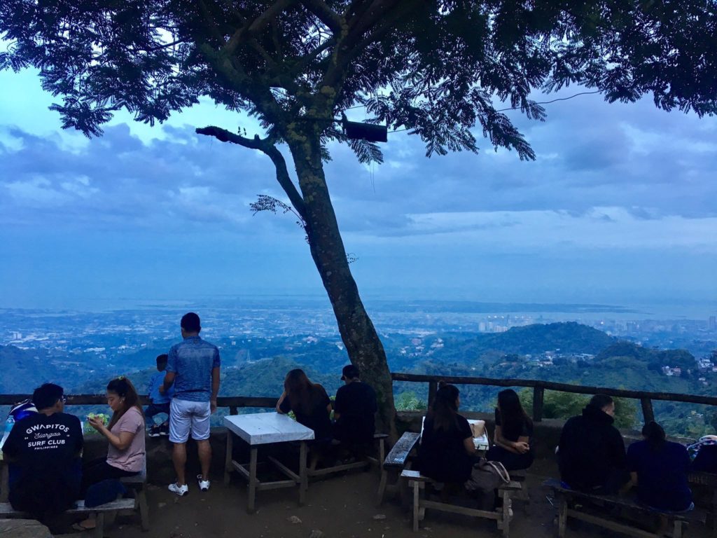 people sitting on a bench overlooking a valley