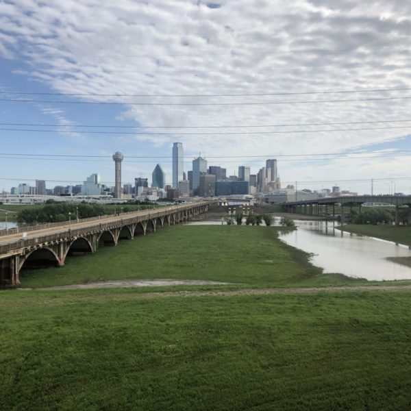 a bridge over a river with a city in the background