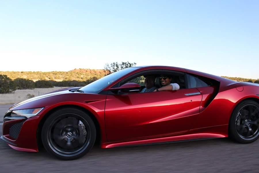 a red sports car with a man in the driver's seat