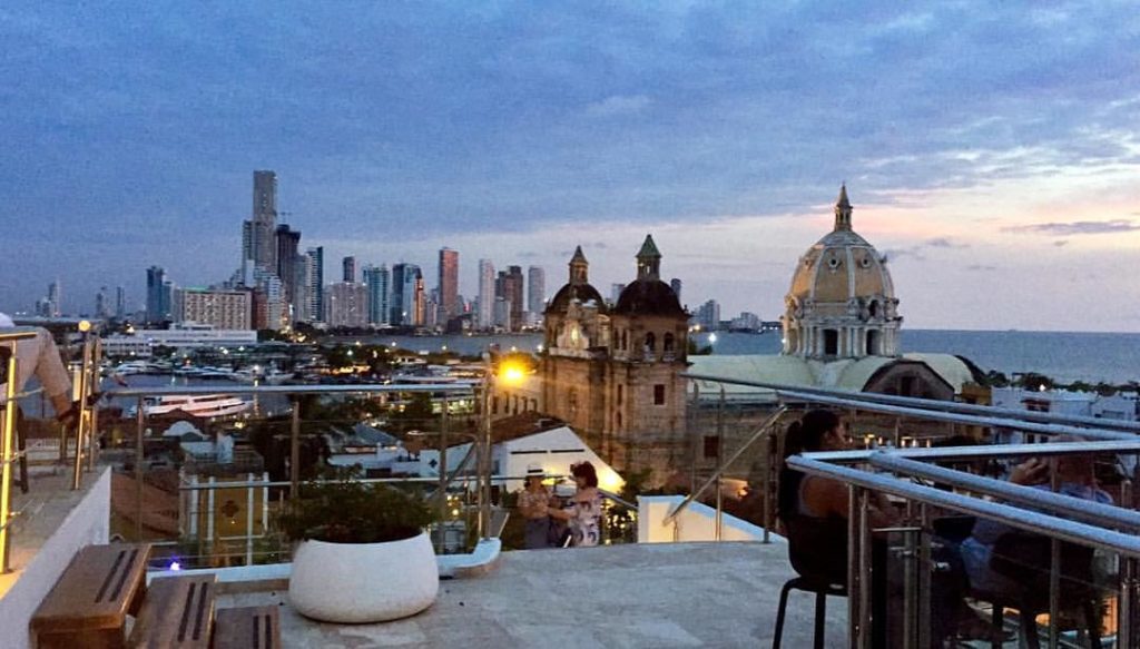 a rooftop view of a city with a large building and a bridge