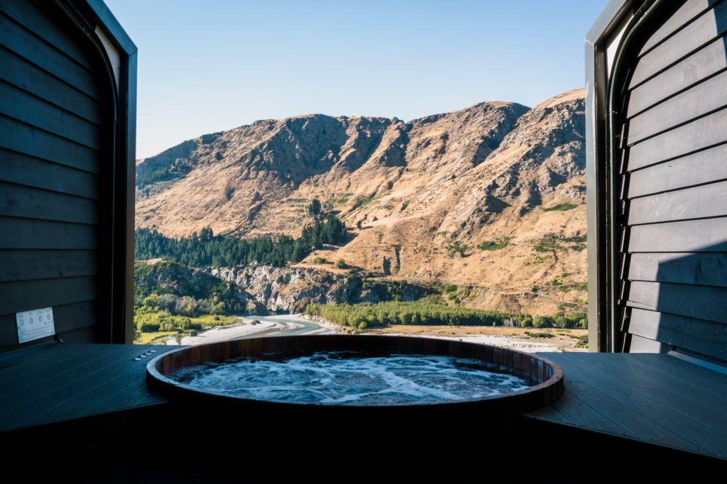 a window with a tub and a view of mountains