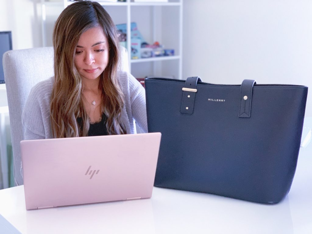 a woman sitting in a chair looking at a laptop