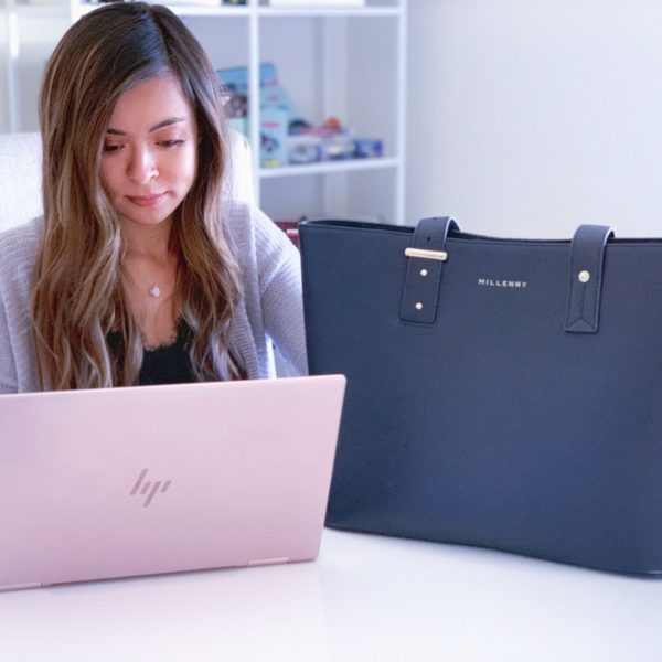 a woman sitting in a chair looking at a laptop