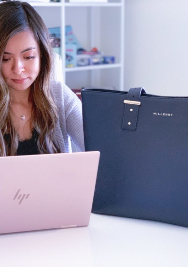 a woman sitting in a chair looking at a laptop