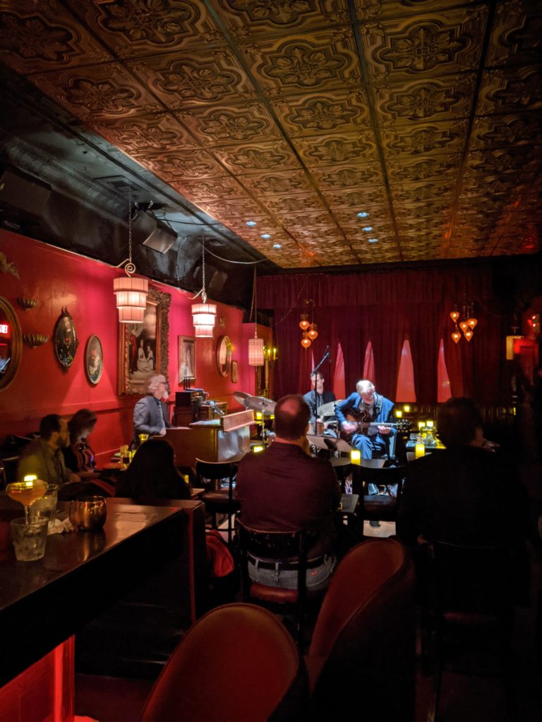 a group of people sitting at tables in a room with red walls