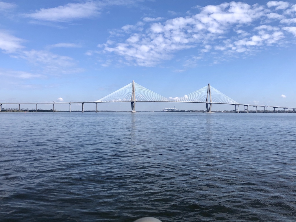 a bridge over water with clouds in the sky