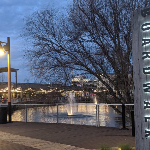 a sign with a fountain in the water