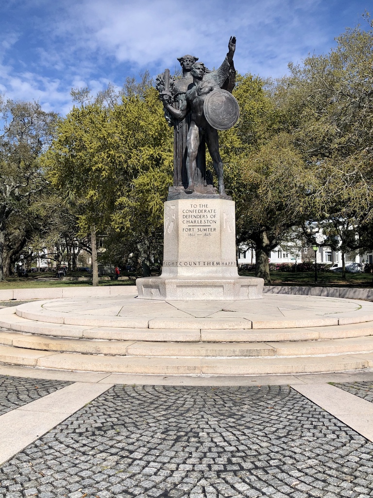 a statue of a man with wings and a shield on a pedestal