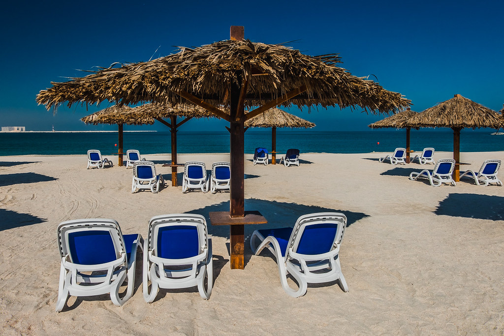 a beach with chairs and umbrellas