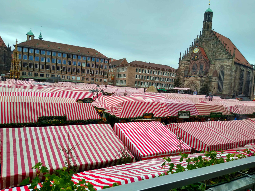 a group of tents with red and white striped tents in a city