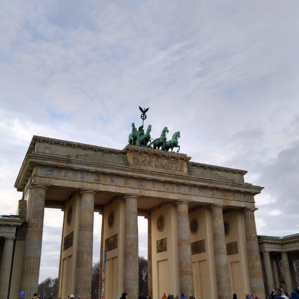 a large stone structure with a statue of horses on top with Brandenburg Gate in the background