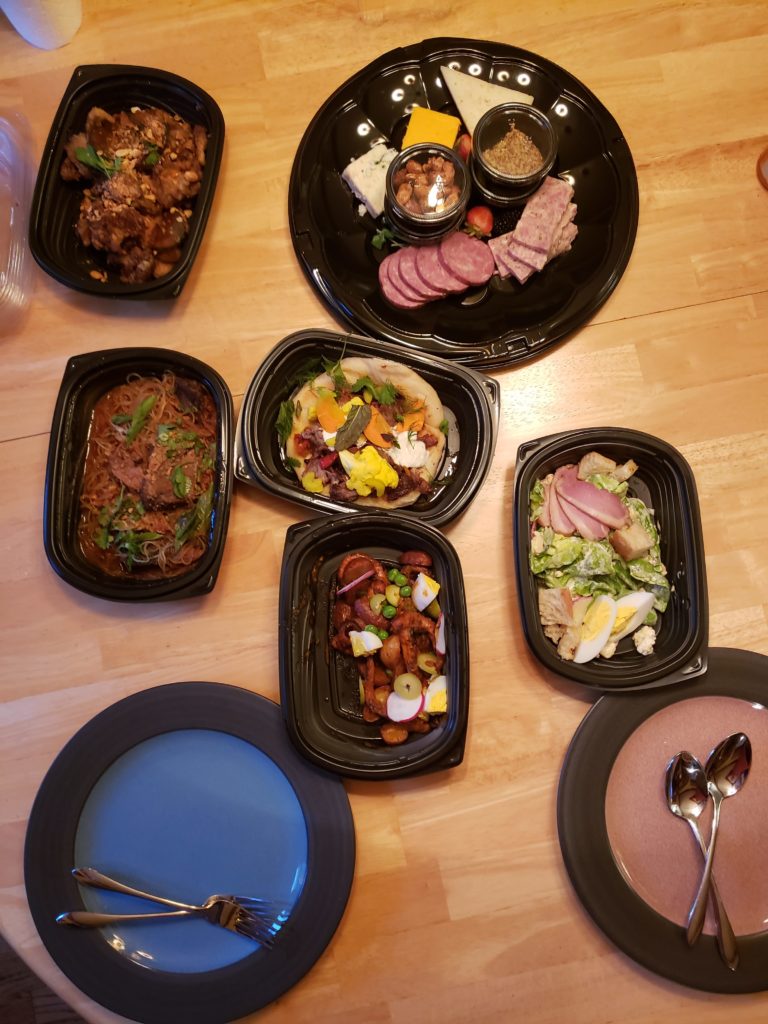 a group of black plastic containers with food on a table