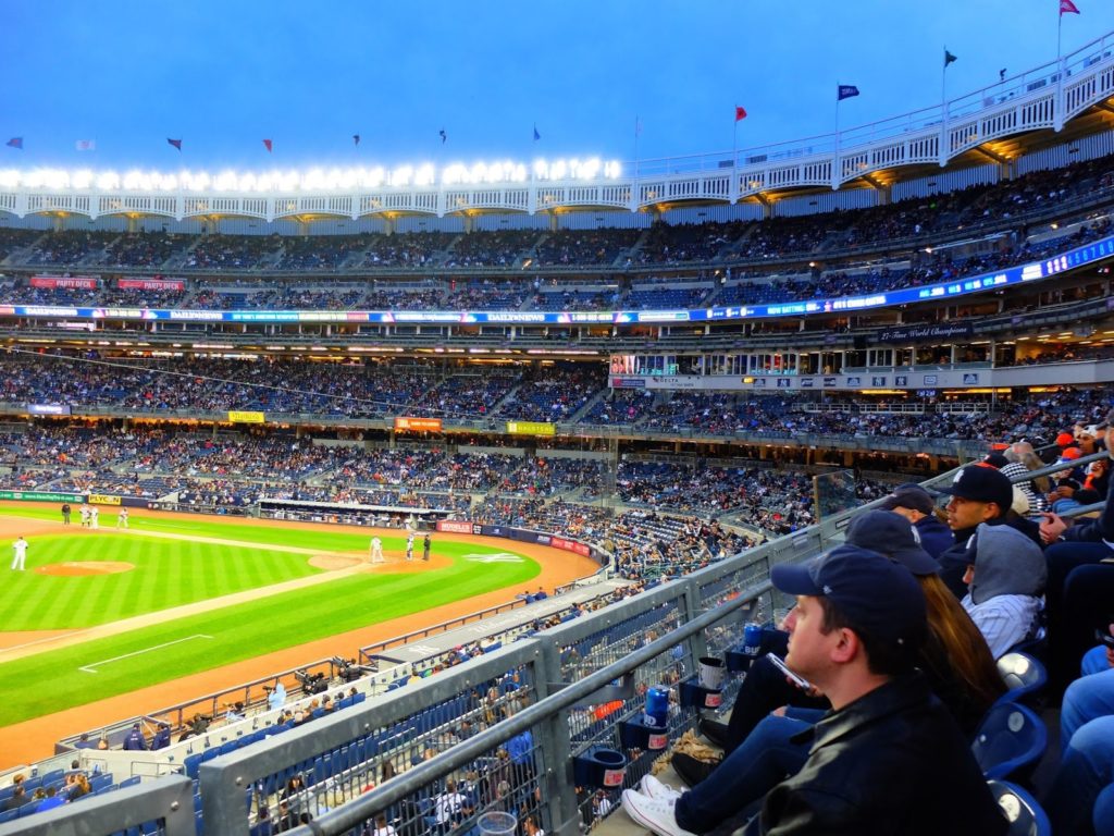 a baseball stadium with people watching a baseball game