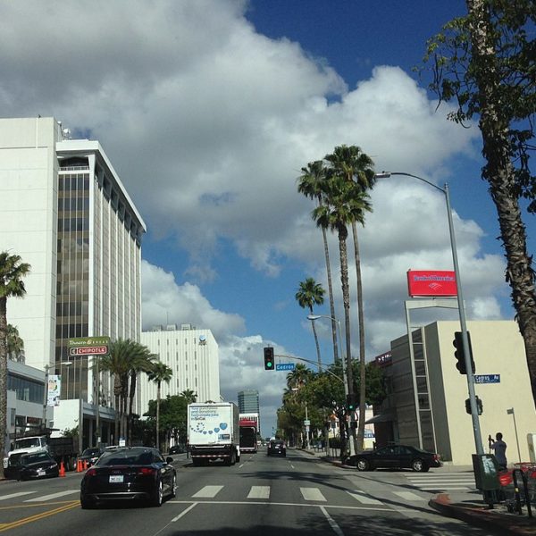 a street with cars and palm trees