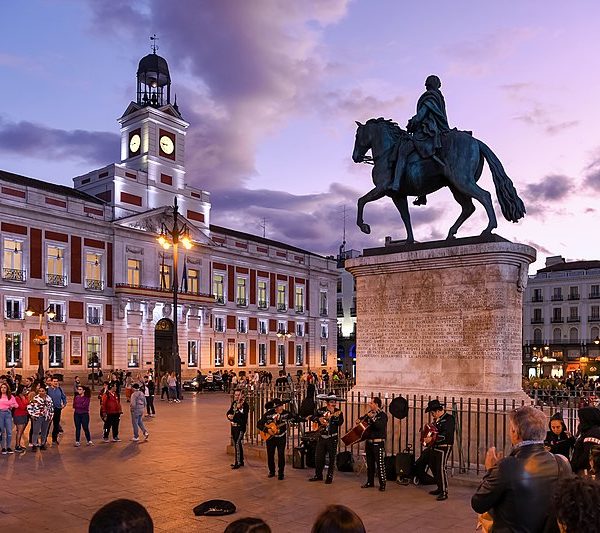 a group of people in front of a statue of a man on a horse