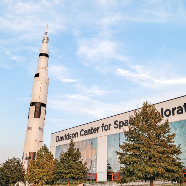 a white rocket in front of a building