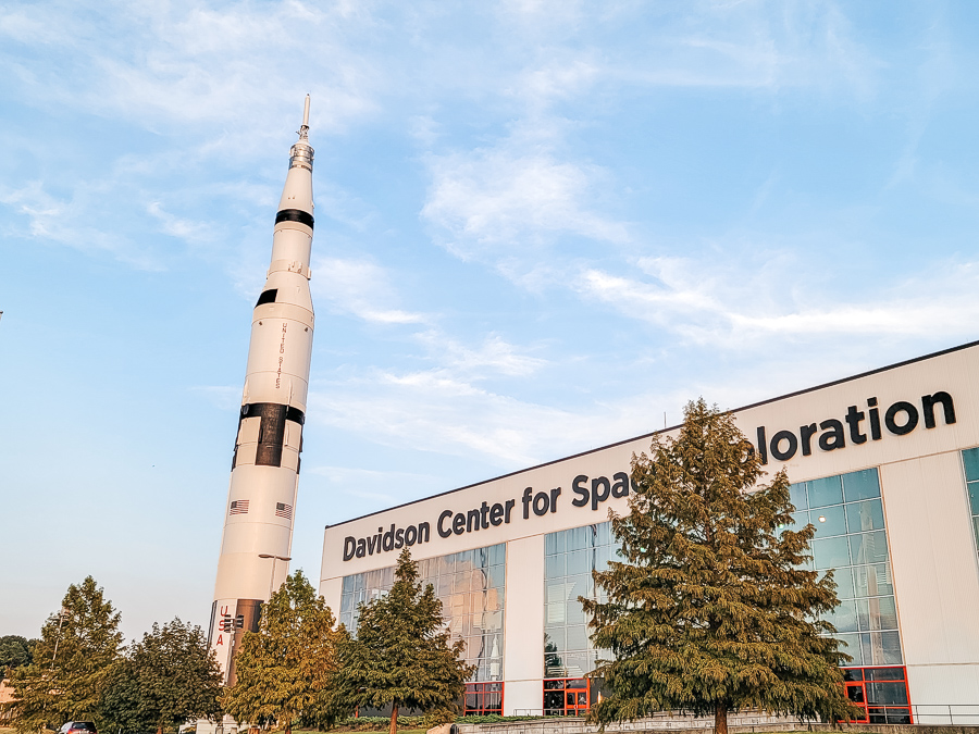 a white rocket in front of a building