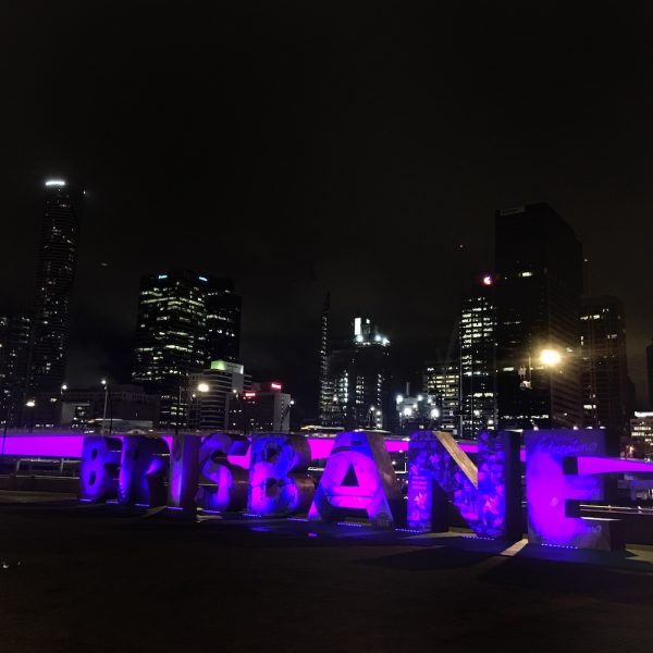 a city skyline at night with purple letters