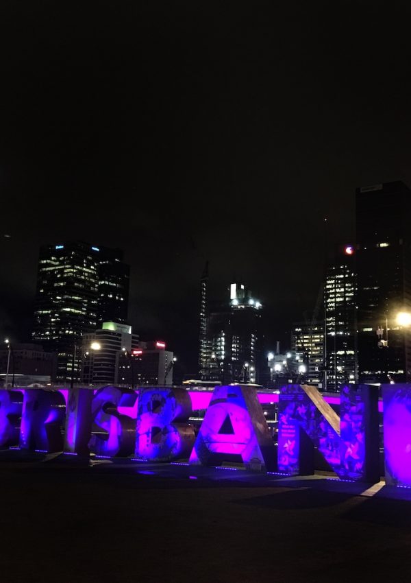 a city skyline at night with purple letters