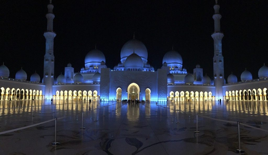 a large white building with domes and lights at night