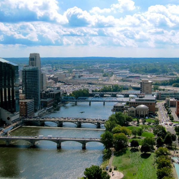 a bridge over a river with a city in the background