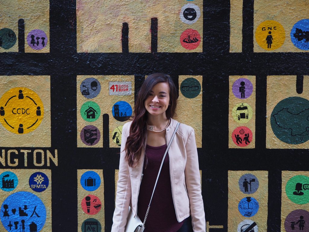 a woman standing in front of a mural