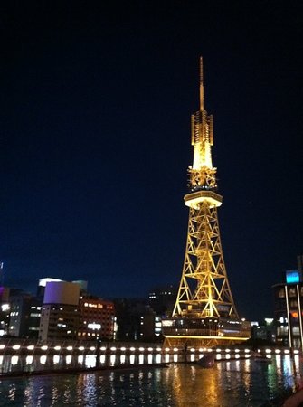 a tall tower lit up at night with Nagoya TV Tower in the background