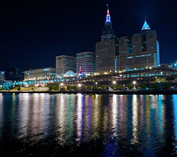 a city skyline with lights and a body of water